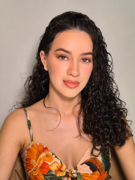 Maquiagem com pele natural em cliente de cabelo cacheado